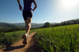 Woman running on trail thru meadow
